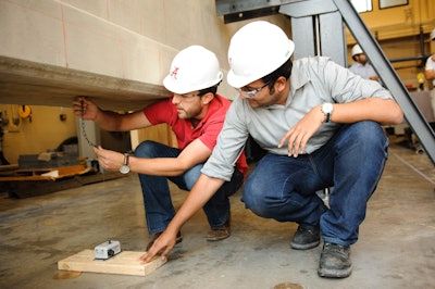University of Alabama graduate students David Burkhalter, left, and Vidya Sagah Ronanki work on a concrete girder in the Large Structures Lab on UA’s campus.