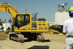 A Komatsu drone operator pilots his aircraft over a Smart Construction jobsite.