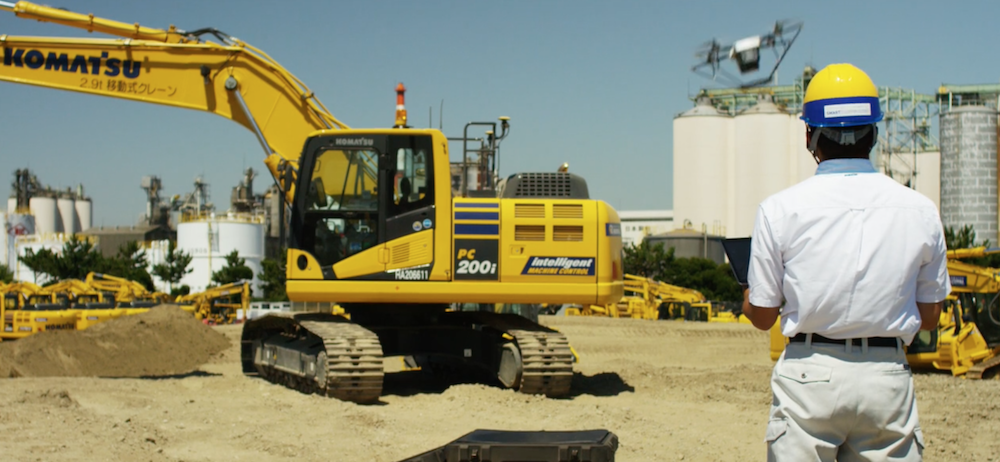 A Komatsu drone operator pilots his aircraft over a Smart Construction jobsite.