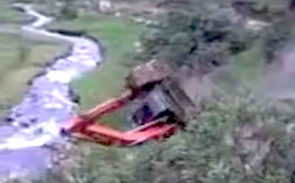 Excavator rolls into creek