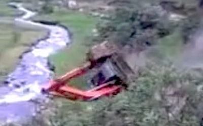 Excavator rolls into creek