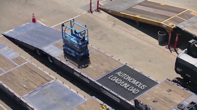 A scissor lift loads itself onto a truck at a United Rentals yard using autonomous technology developed by 5D Robotics.