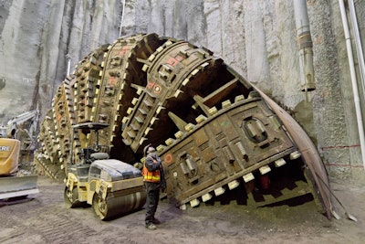 A worker with Seattle Tunnel Partners watches as co-workers are lifted out of Bertha’s repair pit Dec. 15, 2015. With repairs complete, crews filled the hole in in order to begin tunneling with the machine after a 2-year delay. Photo Credit: WSDOT Flickr