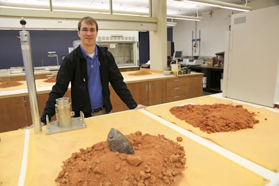 W. Griffin Sullivan in MDOT’s Materials Lab with a tool used to interface design and construction that was developed through the research presented in the awarded paper.
