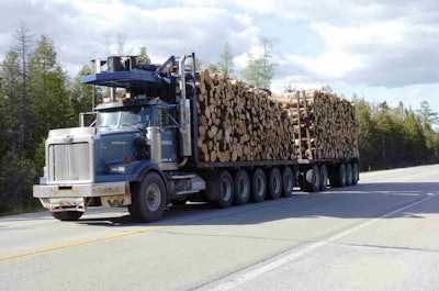 A logging truck drives down an Upper Peninsula road. Seasonal weight restrictions are designed to protect state roads during the spring thaw when they’re most vulnerable to damage. (MDOT Photo)