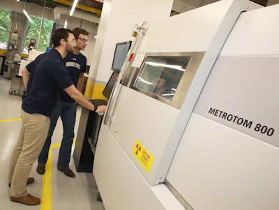 Clayton Greer (front) is the graduate student working on the design of the excavator boom and bucket. He and James Collins, an undergraduate research assistant, are pictured working with a micro-computed tomography machine. Photo credit: Georgia Institute of Technology