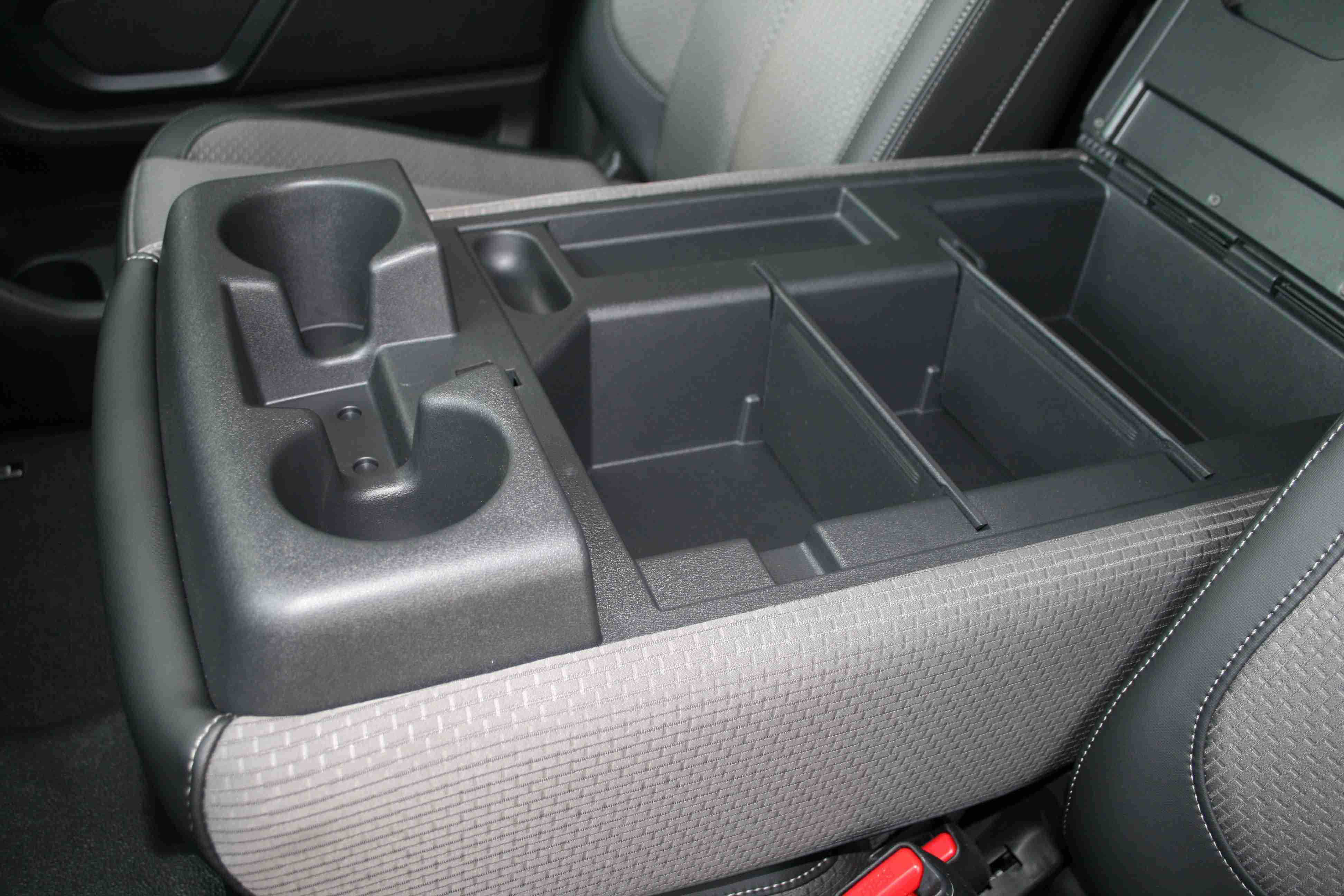 The fold-down armrest in the 2017 Titan XD Standard Cab offers two more drink holders for a total of eight. Also, notice the removable dividers inside the storage compartment. Nice!