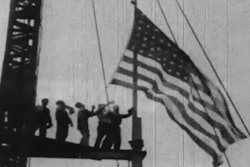 Workers raise the American flag during construction of the Empire State building.