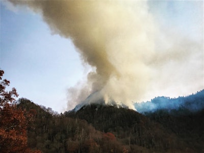 A photo from Nov. 27 shows smoke atop Chimney Tops, the mountain in Great Smoky Mountains National Park where the recent Gatlinburg/Pigeon Forge wildfire originated. Photo credit: Wayne Grayson