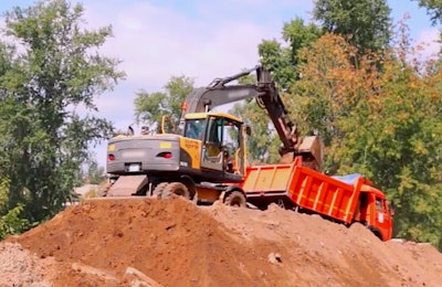 excavator-loading-truck-stock