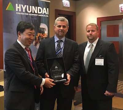 Accepting the Dealer of the Year award from Hyundai CE Americas President M.S. Kang (left) are Rob Lynch (center), president of Rob’s Hydraulics, Grimesland, North Carolina, and Jason Wainwright, sales manager, Rob’s Hydraulics.