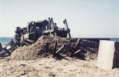 A military variant of the Power Dozer breaching and clearing a minefield “littered with jersey barriers and tetrahedrons.” Photo credit: Power Dozer