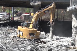 An excavator works as part of demolition efforts in the wake of a collapse of a portion of I-85 in Atlanta.