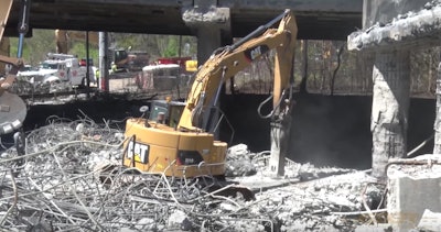An excavator works as part of demolition efforts in the wake of a collapse of a portion of I-85 in Atlanta.
