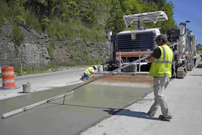 Concrete pavement is hand finished in advance of tining.
