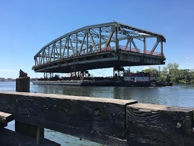 The main span of the old Kosciuszko Bridge being the floated out to the East River, from where the main span was to be taken to a recycling facility. (Skanska USA)