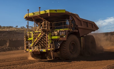An autonomous Cat 793F CMD mining truck leaves an iron ore pit at Fortescue Metals’ Solomon Hub.