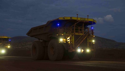 Cat 793 F Cmd Mining Trucks Operating At Dusk 3
