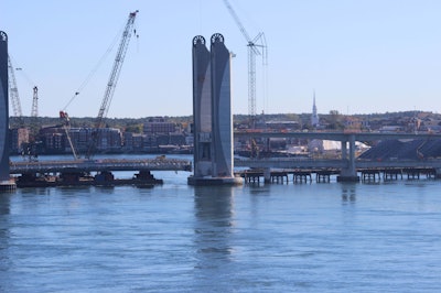 A barge floats the new lift span into place with help from the tides.