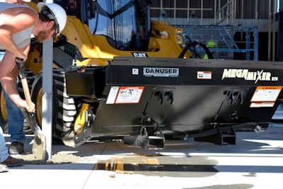 Material collected in the MegaMixer’s hopper is dispensed on either side of the attachment.