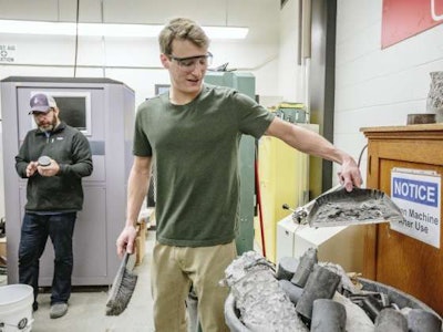 Professor Mike Berry, left, and student researcher Riley Scherr perform compression tests on ultra-high performance concrete at Montana State University. MSU photo by Adrian Sanchez-Gonzalez.