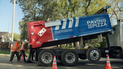Dominos is saving pizza, one pothole at a time. Cracks, bumps, potholes and other road conditions can put good pizzas at risk after they leave the store. Now Dominos is hoping to help smooth the ride home by asking customers to nominate their town for pothole repairs at pavingforpizza.com. (PRNewsfoto/Domino’s Pizza)