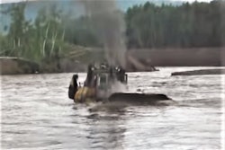 Dozer wades through river
