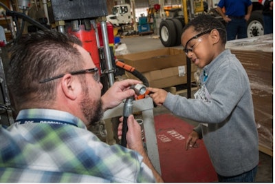 Make-A-Wish kid Samuel and Caltrans Equipment Shop staff explored DOT equipment before Samuel hit the road to have his wish realized of seeing a real spaceship at the Kennedy Space Center. This photo by Caltrans Senior Photographer Scott Lorenzo won grand prize in an AASHTO-sponsored contest.