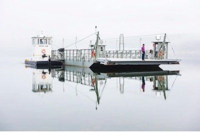 The Peel Ferry glides through the early morning fog on Bull Shoals Lake. As the last operational ferry in Arkansas, it provides a connection in the north-central portion of the state to Missouri. ARDOT employees Rob Mersman (tug pilot) and Randall Williams (on barge deck) operate the ferry. Arkansas DOT photographer Rusty Hubbard took this prize-winning shot.