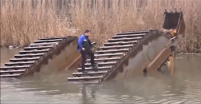 Man standing on amphibious excavator