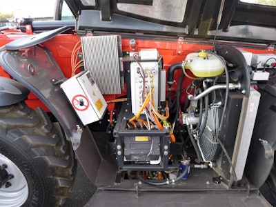 The batteries and power control modules are mounted to the left of the cab.