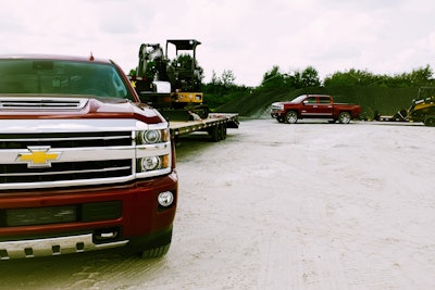 chevy silverados hailing trailers with john deere equipment
