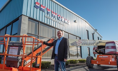 Jerry Reinhart Jr., founder and president of Skyworks, poses with this commemorative JLG 660SJ, outside his rental company in Buffalo, New York.