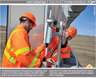 Two workers installing roadside units along Interstate 80 in Wyoming