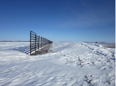 Fence standing in a field of snow