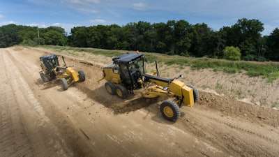 The Cat 120 motor grader has two different cab styles, one for wheel/lever controls (right) and another for the joystick controls (left).