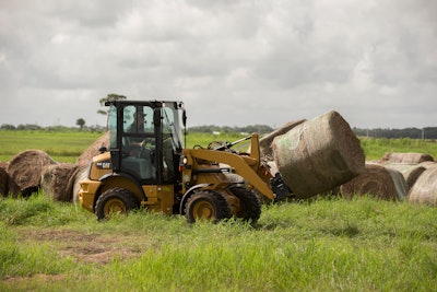 Cat 903D moving a bale of hay