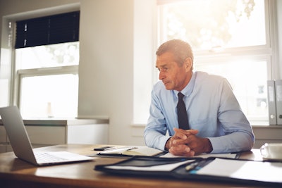 Businessman sitting at desk with laptop