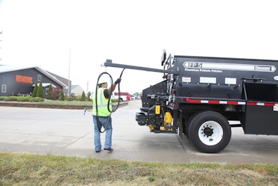 The pivot tack hose system attaches to the back of the FP5 Flameless Pothole Patcher.