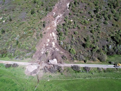 An aerial shot of CO 145 where two massive boulders fell onto the highway. The one on the right, estimated to weigh 2.5 million tons, was blasted so a temporary road could be opened. The boulder on the left is estimated to weigh 8 million pounds, and the CDOT may just leave it where it is.