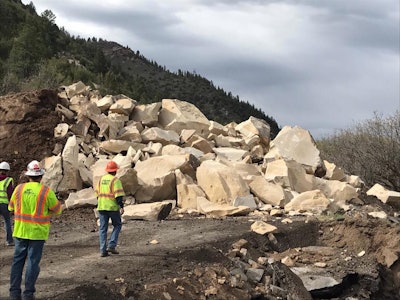 The remains of the blasted boulder were hauled off to open a temporary road.