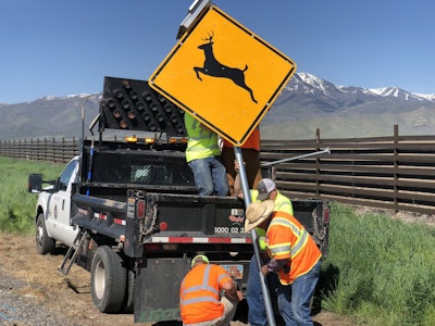 Workers with the Utah Department of Transportation install newly developed radar-detection wildlife signs.