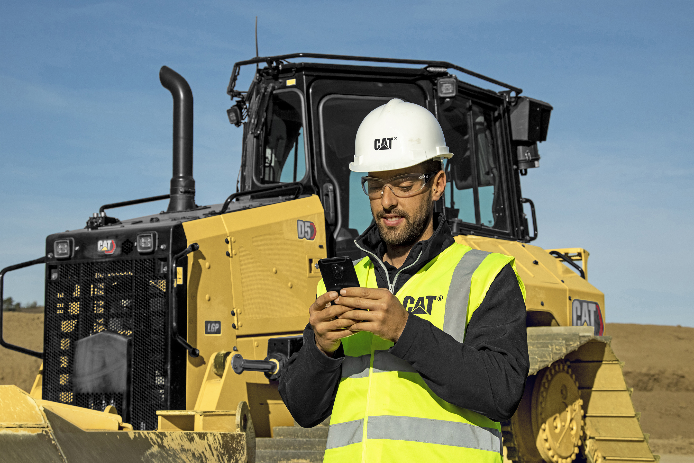 Worker with phone Cat D5 dozer