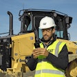 Worker with phone Cat D5 dozer