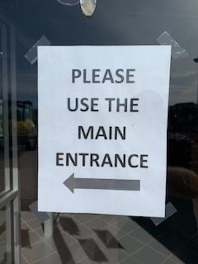 Sign at Franklin Equipment entrance directing visitors to use one door.