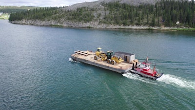 Equipment heads up river on one of Drake’s smaller barges.