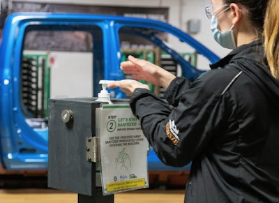 An FCA factory worker sanitizes her hands on the assembly line. Getting back to work means wearing masks, sanitizing and practicing social distancing. It’s gonna be hard for the huggers, hand shakers and high-fivers among us.