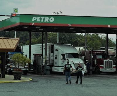 Couple holding hands walking towards Petro fuel pumps