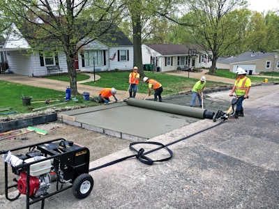 Men using custom drum to pave concrete