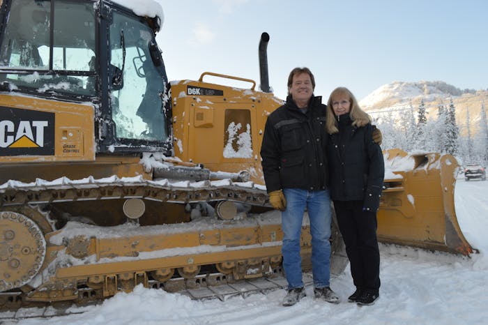 Dirtworks Scott and Dianne Johnson standing in front of a track loader